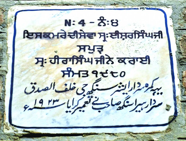 A marble plaque on the wall of a corridor in the school