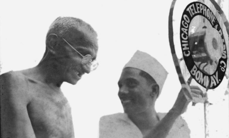 Nanik Motwane showing Gandhi his microphone during a meeting in Karachi in 1929