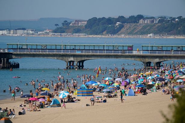 People gather in the hot weather at Bournemouth beach, Dorset