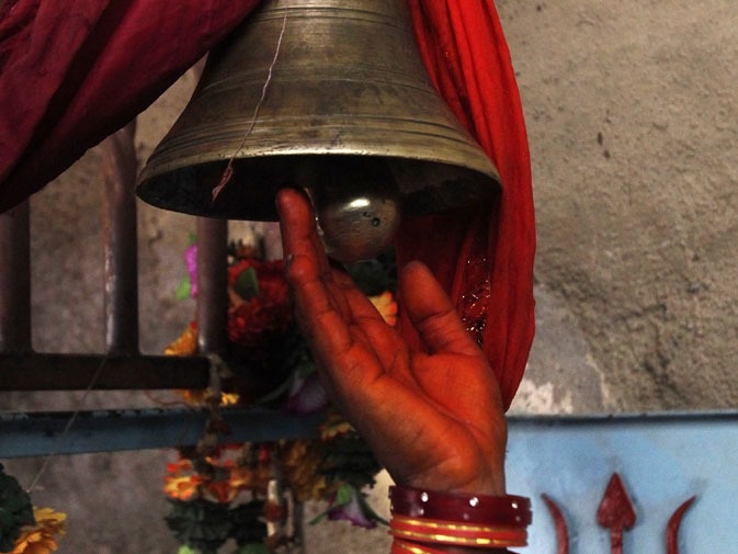 0- A devotee strikes a bell as she enters the Hinglaj Mata Mandir