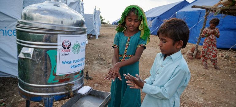 Displaced children wash their hands outside a public toilet at a camp in Sindh Province Pakistan - Photo UNICEF